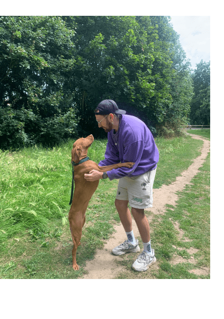 An image of Harvey cuddling a dog