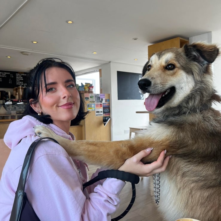 Pet owner looking at the camera whilst holding a dog